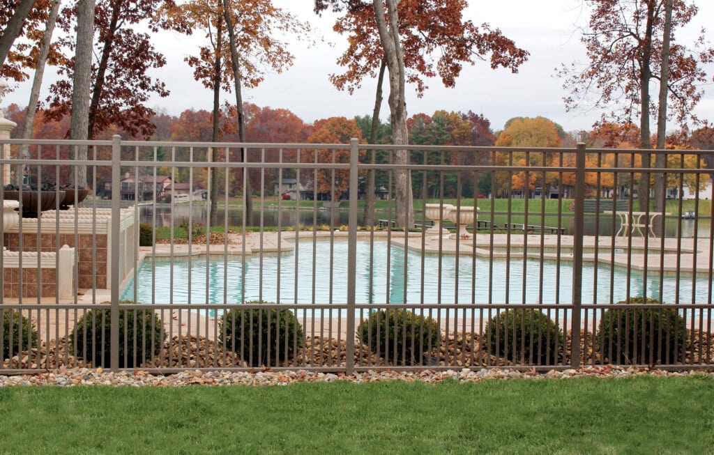 Gorgeous metal fence with a manicured fall backdrop that show how you can boost curb appeal before the holidays.