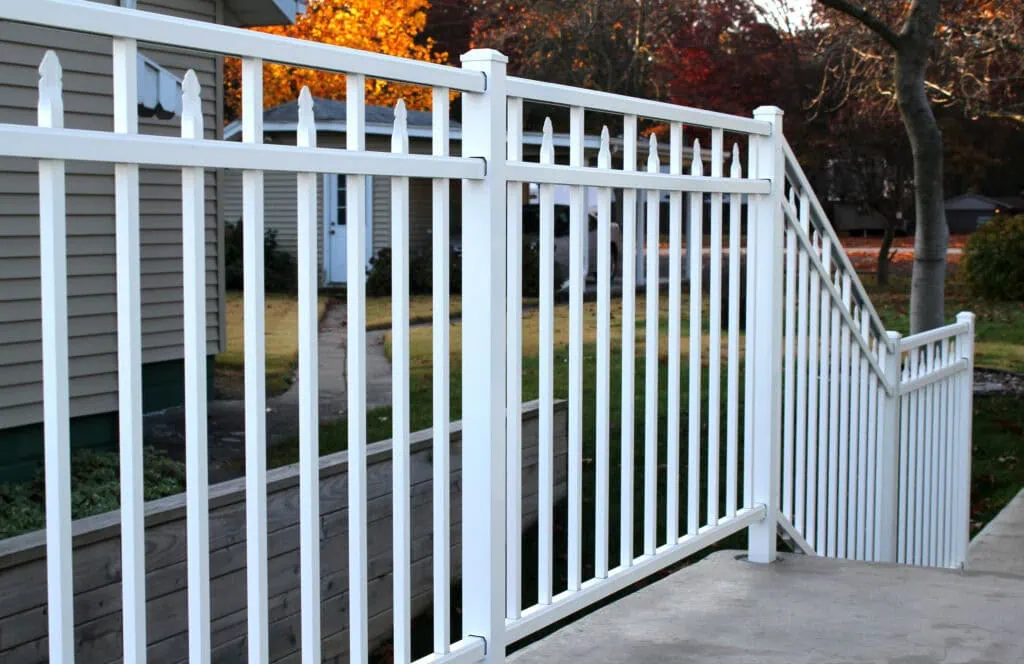 Gorgeous metal fence with a manicured fall backdrop that show how you can boost curb appeal before the holidays.