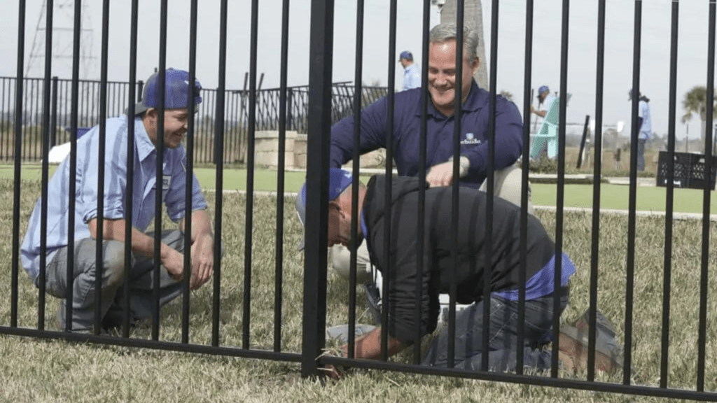 Three smiling Best Fence employees installing a new fence.