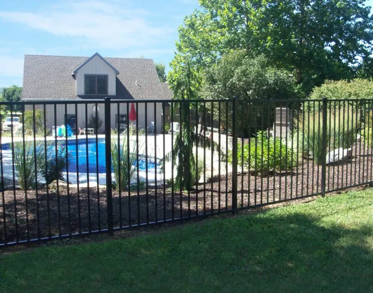 Backyard pool with black aluminum fencing.