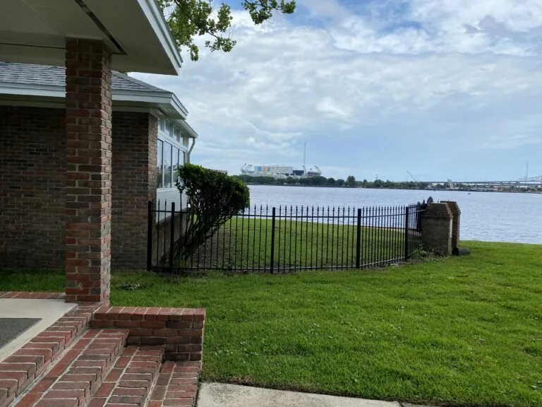 Home on the water with black aluminum fence.