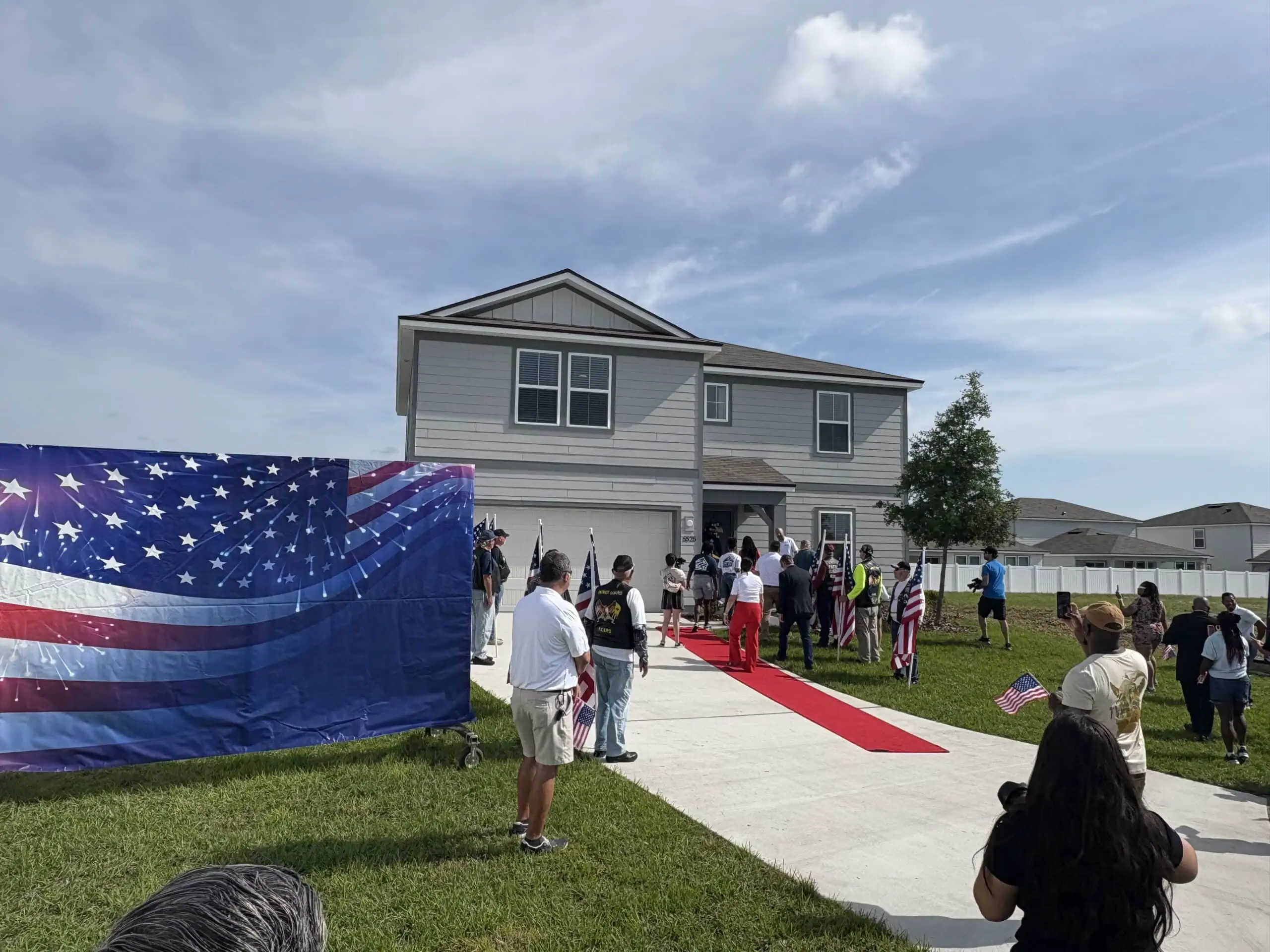 Home for a Veteran. Red carpet rolled out in driveway to welcome the family home.