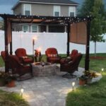 Backyard fire pit and chairs surrounding it with torches lit for evening ambiance.