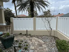 Pretty white vinyl fence near walkway.