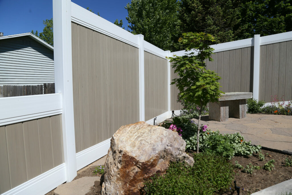 Vinyl fence along a rock garden.