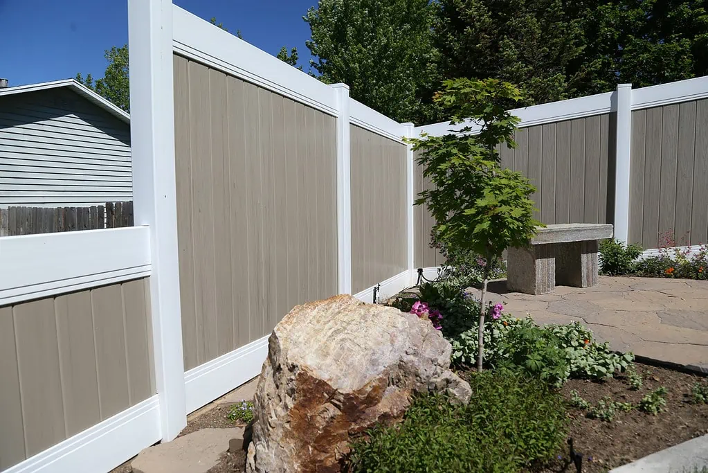 Vinyl fence along rock garden.
