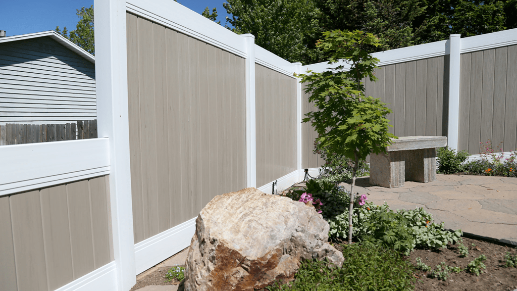 Two tone vinyl fence and rock garden