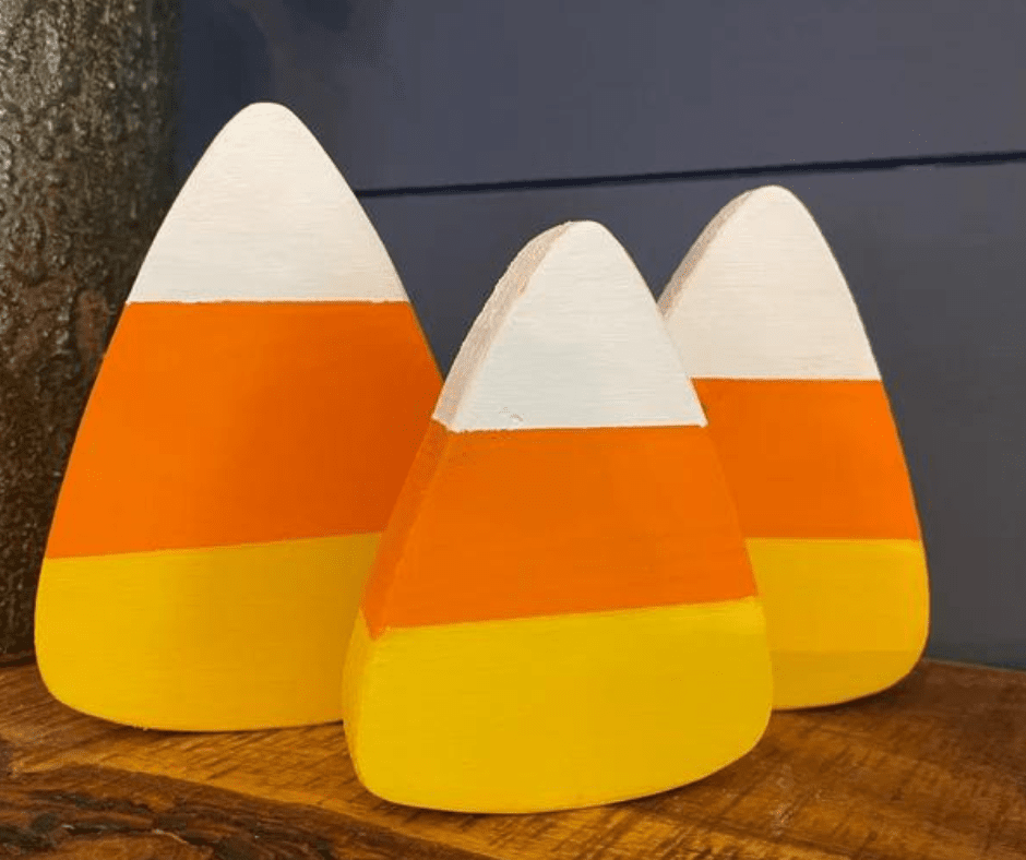 Wooden candy corn Halloween decorations by a front door.