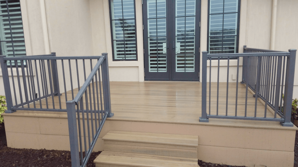 Railing around a square porch with stairs.